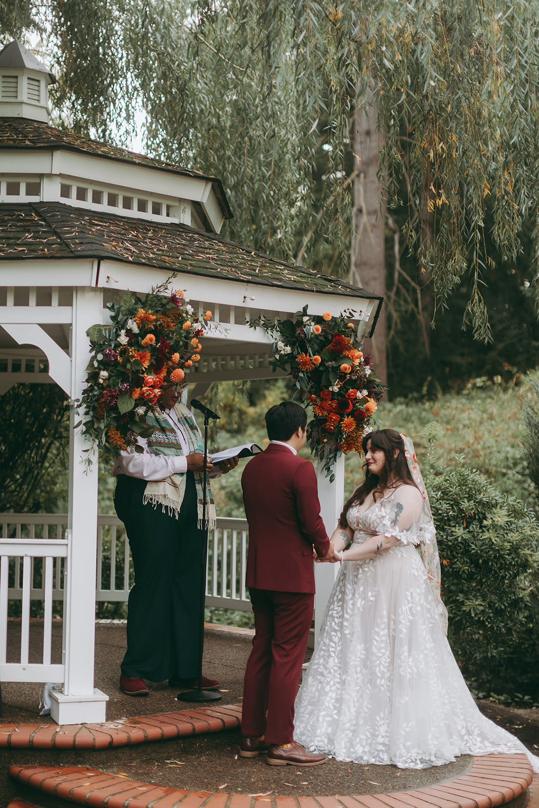 Riley & Rob bride and groom on the redwood observation deck under their wedding arch of orange poppies